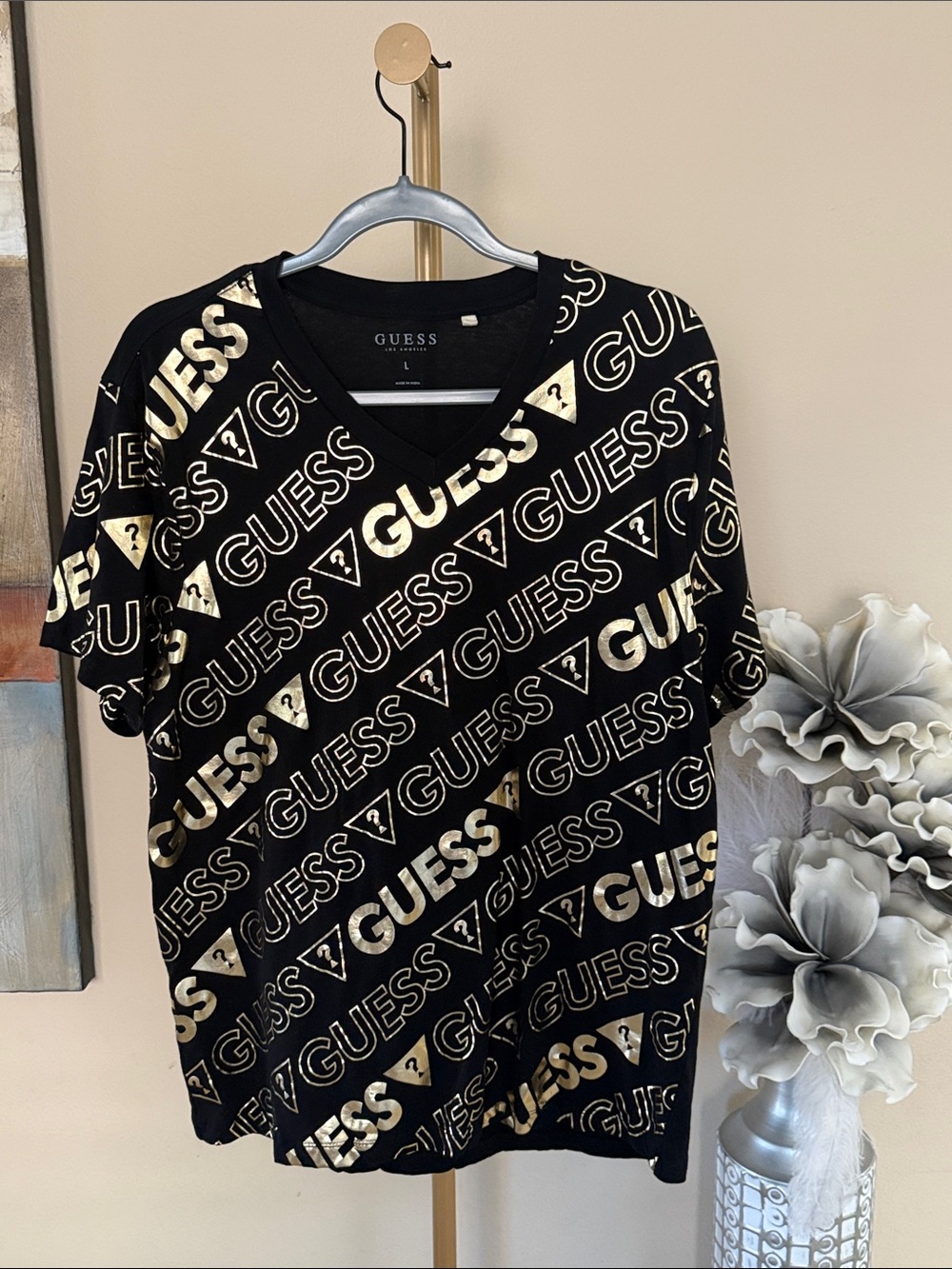 GUESS Black Short Sleeve V‑Neck Tee with Metallic Gold Logo Pattern